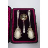 A set of late Victorian servers comprising a pair of fruit spoons, the elongated ovoid bowls with