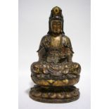 A Chinese carved & lacquered wood figure of the Buddha seated cross-legged on an oval lotus flower