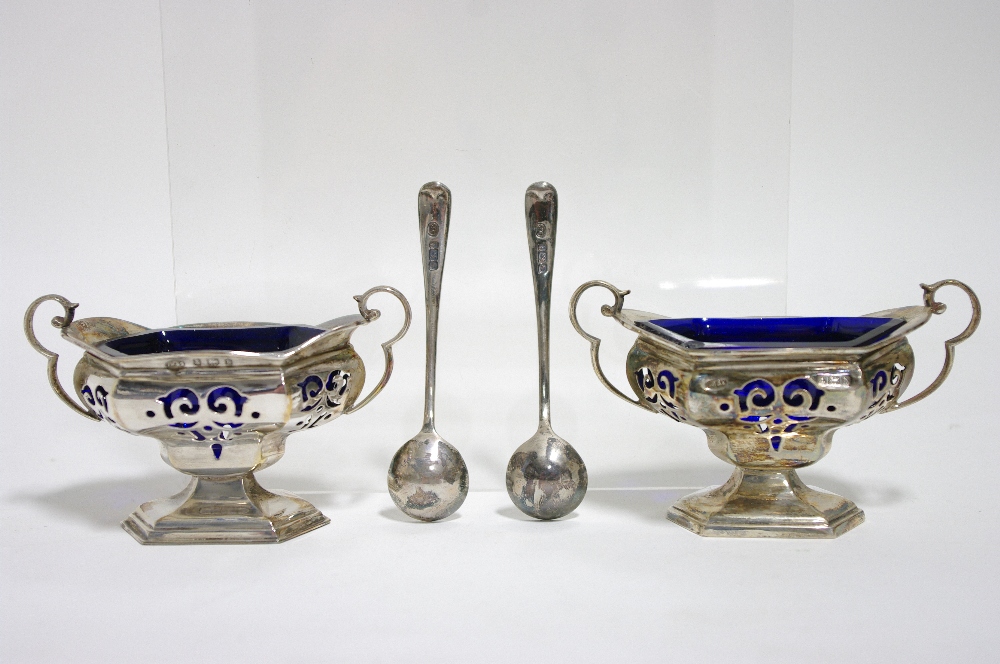 A pair of Edwardian oblong two-handled salt cellar with pierced sides & blue glass liners, each on