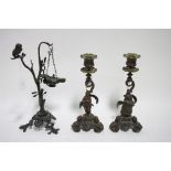 A 19th century bronzed metal roman-style oil lamp suspended from a tree, an owl perched on  the