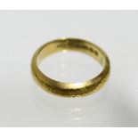 An Edwardian 18ct. gold wedding band with planished surface; Birmingham 1907. (4.2gm)