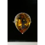 A CITRINE & DIAMOND RING, the pear-shaped centre stone measuring approx. 20mm x 14mm, set within a