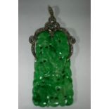 A Chinese carved & pierced jade rectangular pendant of mottled green & white colour, the white metal