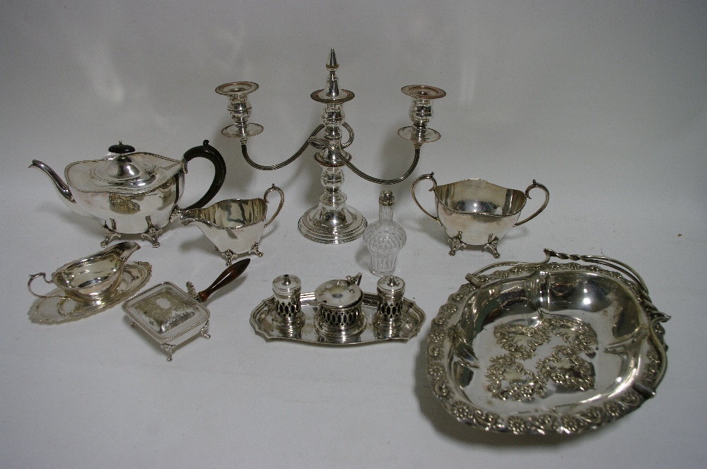 An oval three-piece tea service with narrow decorative borders, each on four scroll feet; an