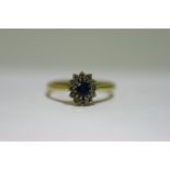 A sapphire & diamond ring, the oval sapphire set within a border of twelve small diamonds, to an