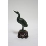 A Chinese carved dark green jade model of a wading bird