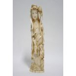 A Chinese carved ivory figure of Guan Yin, the tall slender standing deity dressed in flowing robes,