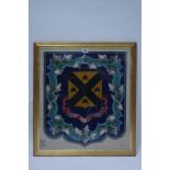 A 19th century embroidered glass beadwork armorial panel displaying the shield & motto of Christie &