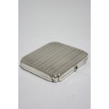 A rectangular engine-turned pocket cigarette case with re-entrant corners & blue hardstone push-