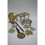 A pierced brass rectangular hob stand; a circular ditto; a brass milk skimmer with long steel