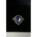 A TANZANITE & DIAMOND RING, the pear-shaped centre stone measuring approx. 10mm x 8mm, set within