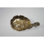 A Victorian caddy spoon with flower handle, & embossed flowers to the crimped oval bowl, 2½" long;