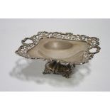 A George V square comport with pierced foliate border, pierced heart-shaped handles, & on short