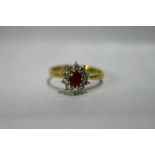 An 18ct. gold ring set oval ruby within a border of small diamonds