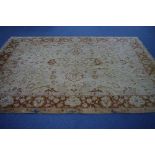 A modern Agra carpet of cream ground with all-over pattern of flowers & palmettes within wide triple