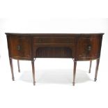 A regency style mahogany bow-front sideboard fitted frieze drawer above a tambour shutter, a