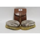 A pair of George V oval planished hair brushes, Sheffield 1926, in leather case.