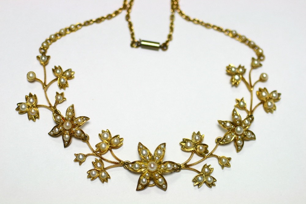 An early 20th century gold flower-design articulated necklace set seed pearls.