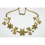 An early 20th century gold flower-design articulated necklace set seed pearls.