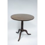 A late 18th century mahogany tripod table with circular tilt top on turned centre column & three