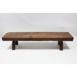 A HEAVY ELM RUSTIC BENCH of long narrow form, on four short square legs; 7’ 2” long x 18” wide x
