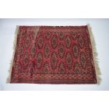 A Bokhara pattern rug of madder ground with repeating guhls pattern, 63” x 51”; & a similar rug with