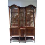 AN EDWARDIAN INLAID MAHOGANY DISPLAY CABINET with arched tops either side of a concave centre,