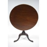 An 18th century mahogany tripod table with circular tilt top on vase-turned centre column & three