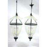 A pair of regency style large clear glass ovoid pendant hall lanterns with smoke shades above; &