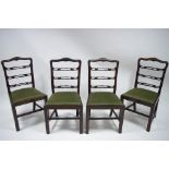 A set of four 18th century style mahogany dining chairs with pierced ladder backs, padded drop-in