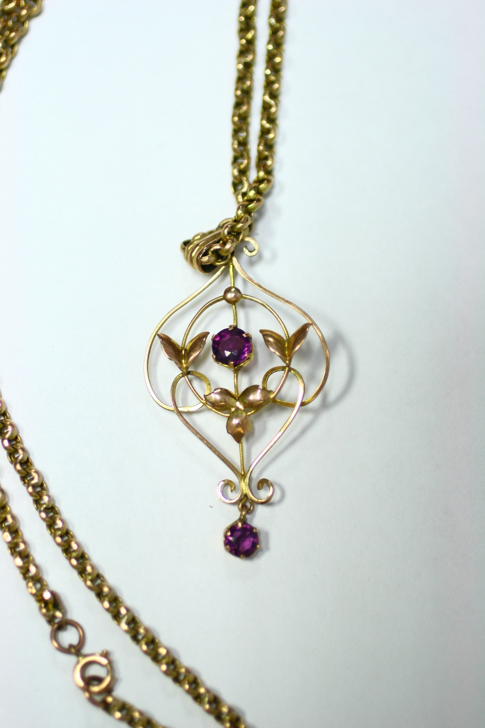 An Edwardian 9ct gold Art Nouveau style floral open-work pendant set centre peridot, on fine-link