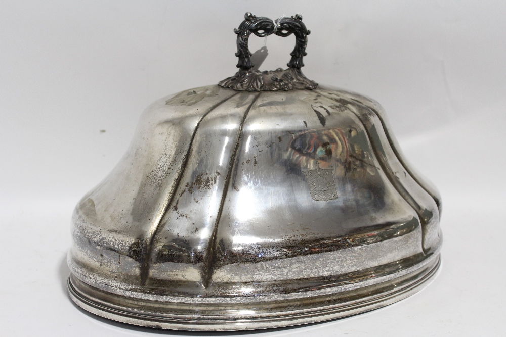 A 19th century large oval fluted domed dish cover with cast foliate ring handle & engraved armorial;