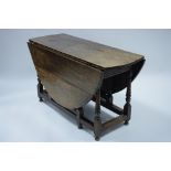 An 18th century oak oval gate-leg table fitted end drawer, on slender baluster turned legs with