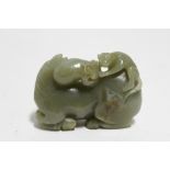A Chinese pale green jade boulder carved as a horse with a monkey on its back; 3” wide x 2¼” high.