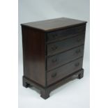 An 18th century oak small chest fitted four long graduated drawers, the brass handles with pierced