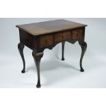 An 18th century style walnut lowboy fitted three frieze drawers above a shaped apron, on four