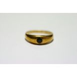 A gold ring with gypsy-set garnet; two 9ct gold rings set small white stones; & an eternity ring set