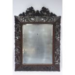 A late Victorian rectangular bevelled wall mirror in wide carved & pierced foliate frame