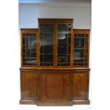 An early 20th century figured walnut small break-front library bookcase, the upper part fitted