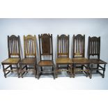 A matched set of six 18th century oak dining chairs with tall rail backs, hard seats, & turned front