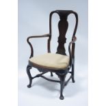 A Queen Anne style walnut elbow chair with shaped splat to the open back, curved open arms, padded