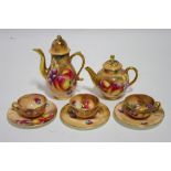 A Royal Worcester porcelain miniature coffee pot, teapot, two teacups & saucers, & a tea plate,