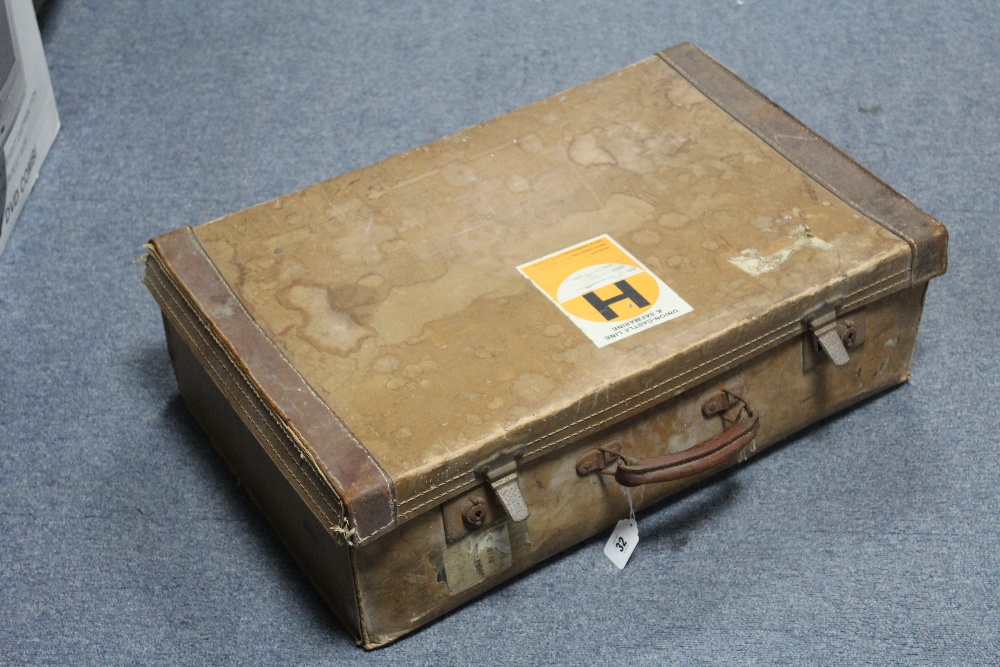 An early 20th century fibre-covered & leather-bound suitcase with chrome twin-lever locks, bears