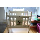 A 1930s/1940s white painted wooden “Mickey Mouse” drop-side cot, 20¾" x 12¾" x 19¾".