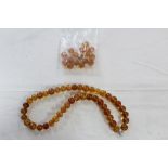 An amber bead necklace (consisting of forty-four beads), 24½" long; and sixteen loose amber beads.