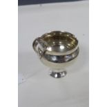 A late Victorian silver cup of globular form, with scroll handle, and on round pedestal foot, 3"