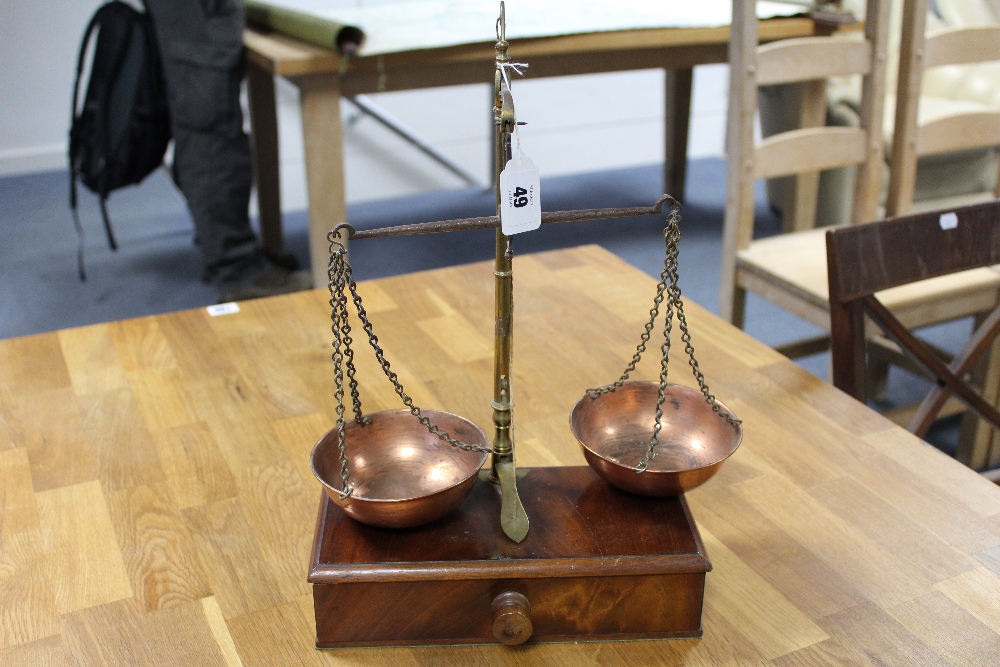 A pair of early 20th century brass beam scales mounted on mahogany box base fitted long drawer, 14¾”