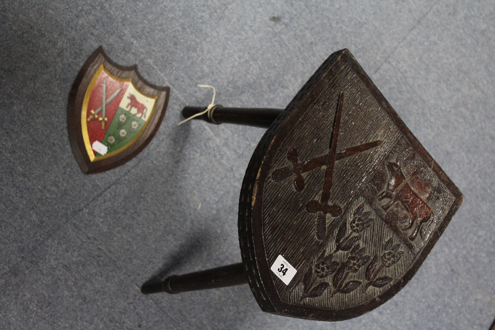 A carved oak stool, the shield-shaped seat depicting the coat-of-arms of “Ridley Hall Theological - Image 2 of 2