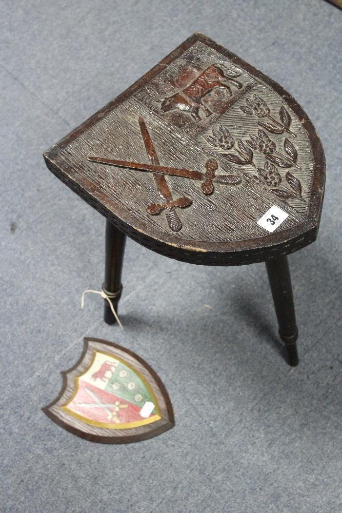 A carved oak stool, the shield-shaped seat depicting the coat-of-arms of “Ridley Hall Theological