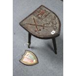 A carved oak stool, the shield-shaped seat depicting the coat-of-arms of “Ridley Hall Theological